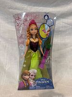 Front view showing Anna doll, wand, and Frozen branding in sealed package