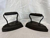 Front angled view of both sad irons showing handles and paint