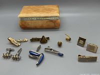 Closed alabaster box with men’s jewellery laid out