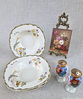 Group shot displaying plates, painting on easel and shakers