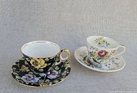 Two floral teacup and saucer sets side by side