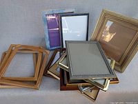 Stacked assortment of 8x10 frames in metal, wood and coloured finishes