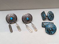 Front view showing both pairs: round silver clip-on earrings with turquoise cabochons and feather dangles; round and rectangular turquoise mosaic cufflinks