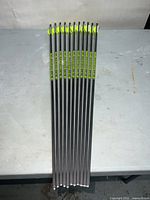 11 carbon arrows laid flat showing shafts, fletching, and nocks
