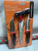 Front view of sealed retail package displaying three knives and Huntshield branding