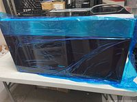 Microwave exterior wrapped in blue protective film