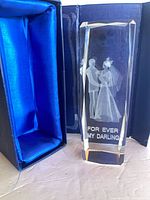 Crystal keepsake standing beside open blue presentation box