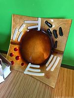 Front view of one fused glass bowl showing amber color and accent elements