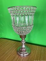 Full view of silver-tone pedestal hurricane candle holder with crystal beads