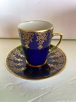 Cup on saucer showing cobalt blue glaze and gold gilt design