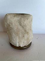 Front view of salt rock candle holder showing overall form on wooden base