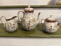 Front view of creamer, teapot, sugar bowl showing overall design and condition