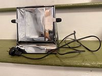 Front view of chrome toaster with cord