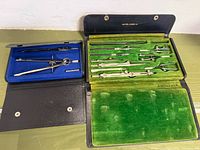 Overview of both drafting sets open showing instruments and cases