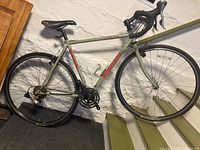 Full side view of Bianchi Volpe bicycle leaning against wall and stairs