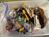 Top view of tote showing loose LEGO bricks, instruction booklets, sealed packs
