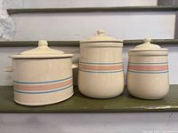 Front view of three McCoy canisters with lids in place