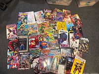 Overhead shot showing approximately forty-six comic books laid out on carpet