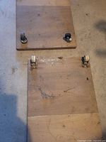 Two plywood boards showing partial caster mounts