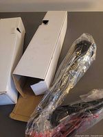 Two boxed microphones, one box open showing plastic-wrapped microphone