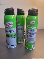 Front and back views of three Turtle Wax Wet'n Black Tire Foam cans