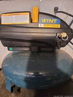 Front view of TNT compressor showing housing and blue tank