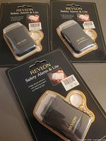 Three packaged Revlon Safety Alarm & Lite keychains