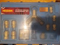 Closed blue case showing Nelson 24 Piece Brass Accessory Kit label and contents through lid