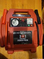 Front view of Centech 3-in-1 portable power pack showing cables, gauge, light and controls