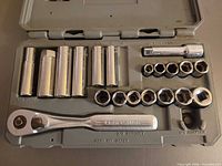 Open case showing ratchet, sockets, extension, adapter