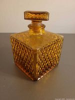 Full view of square amber diamond point glass decanter with stopper