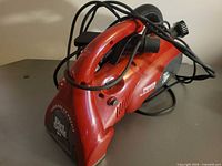 Left-side view of Dirt Devil Power Reach handheld vacuum showing hose and overall condition
