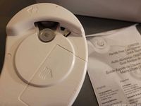 White Orbiter electric hands-free can opener underside alongside quick guide