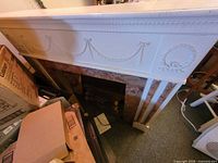 Front view of white mantle showing decorative relief and opening