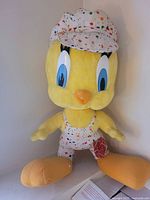 Front view of large Tweety Bird plush with outfit and cap