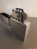 Giant metal lighter open showing chimney and sparkwheel