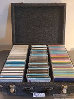 Closed felt CD road case opened to show three rows of CDs