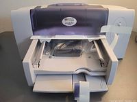 Front view of HP DeskJet 648C printer with tray open, tape intact