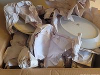 Box containing multiple wrapped china pieces