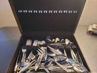 Overall view of flatware set inside wooden chest