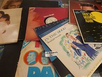 Stack of assorted vinyl records with Bobby Caldwell, “In The Mood,” disco single visible