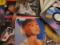 Assorted vinyl records spread, Gloria Estefan cover prominent