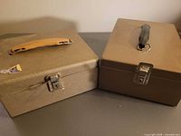 Both cash boxes closed, showing exterior finishes, handles, and latches