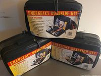 Three black zippered emergency roadside kits arranged together