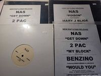 Four vinyl records showing labels and promo inserts