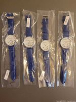 Four identical blue-strap watches in plastic