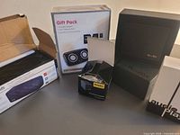 Five boxed Bluetooth speakers on table