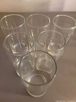 Top view of six clear glass tumblers showing rim condition and clarity