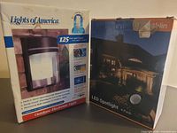Two boxed outdoor lighting products on table