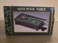 Front of boxed mini pool table set showing product image and accessories